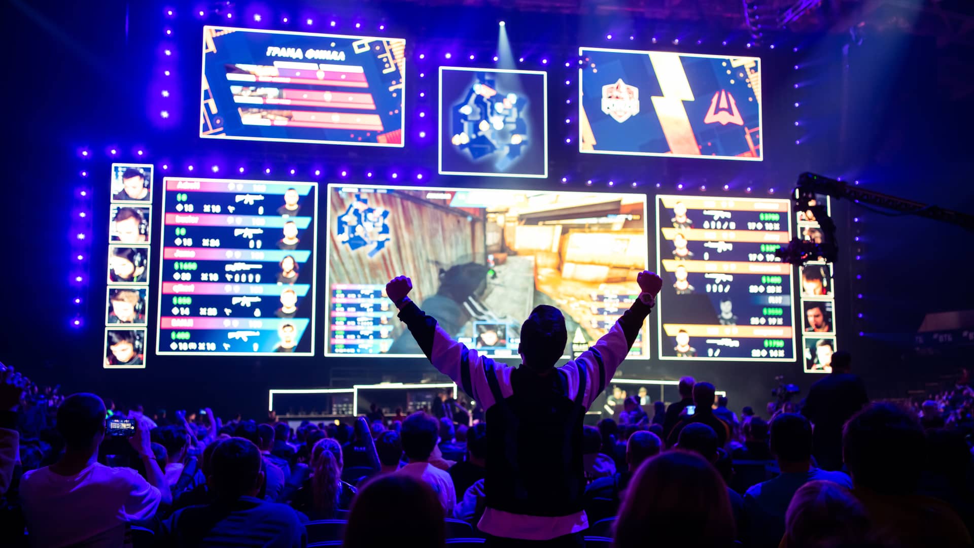 Un evento de videojuegos donde se ve a mucha gente mirando unas pantallas mientras uno celebra la victoria