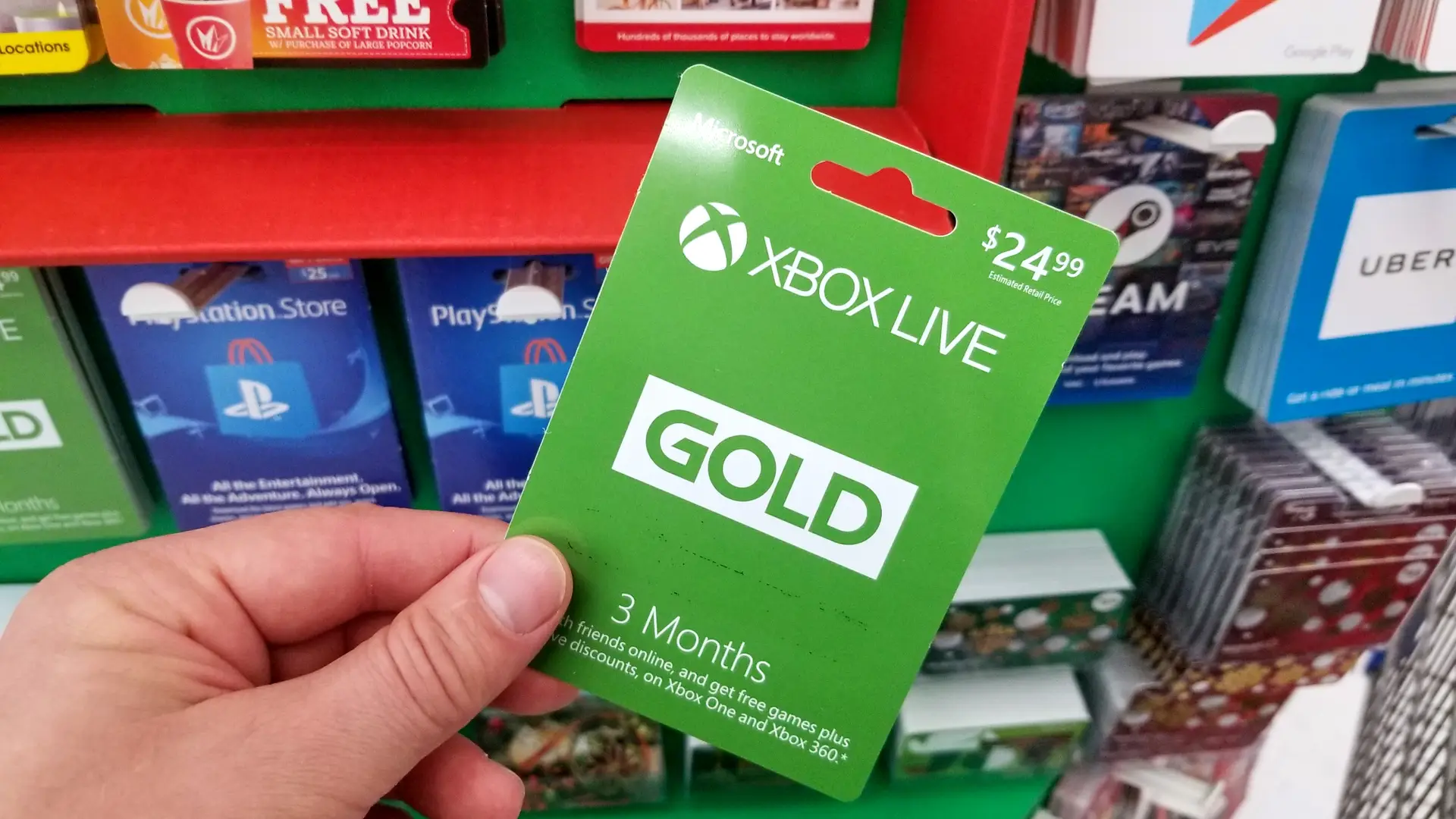 Una personasujetando una tarjeta de Xbox Live Gold para representar como convertir ese servicio en el Game Pass